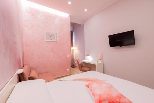 a bedroom with a bed and a tv on the wall at Enchanting Suites Salerno in Salerno