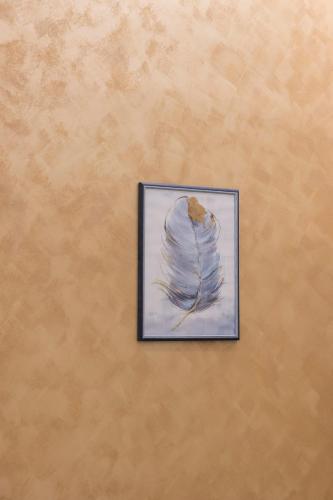 a painting of a feather on a wall at Enchanting Suites Salerno in Salerno