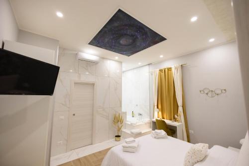 a white bathroom with a shower and a television at Enchanting Suites Salerno in Salerno
