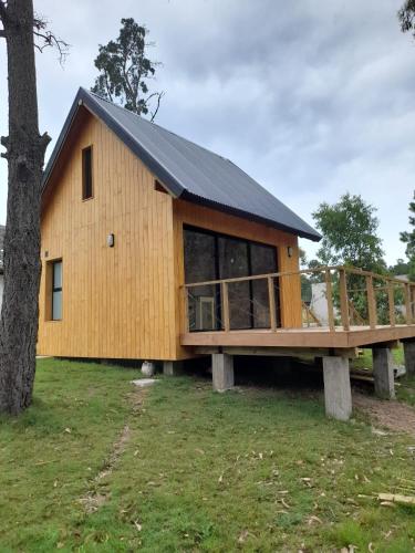 une grande maison en bois avec une grande terrasse dans l'établissement Cabaña nórdica en la naturaleza, à Punta Ballena
