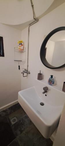 a bathroom with a white sink and a mirror at The Retreat in the heart of Old Town Rhodes in Rhodes Town