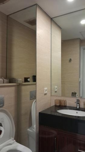a bathroom with a toilet and a sink and a mirror at Ruby Apartment #23 in Yogyakarta