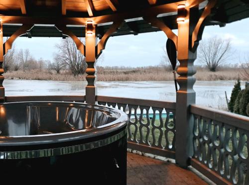 a hot tub on a gazebo with a winter view at Hygge Domki in Junoszyno