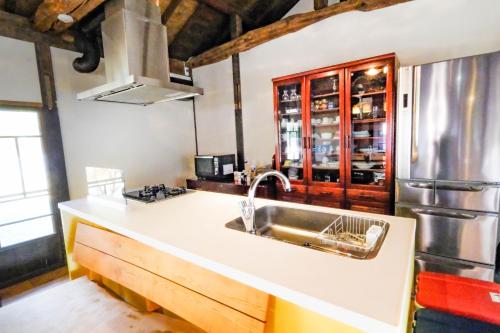a kitchen with a sink and a refrigerator at しまなみ宿Gyoku in Imabari