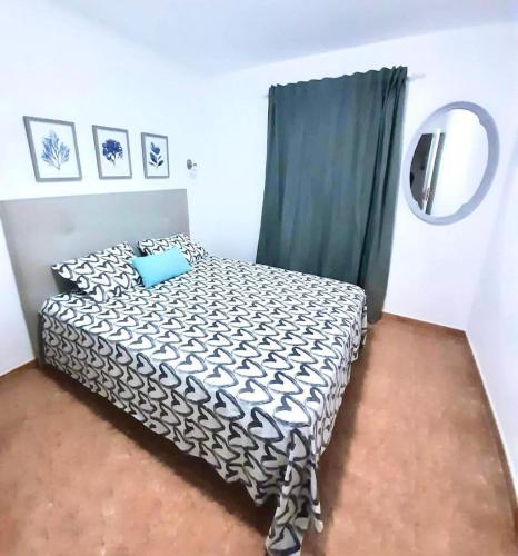 a bedroom with a black and white bed and a mirror at Apartamento Lory-Puerto del Carmen in Tías