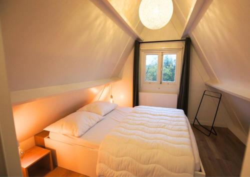 a bedroom with a white bed in a attic at Het mooiste vakantiehuisje in Durbuy in Durbuy