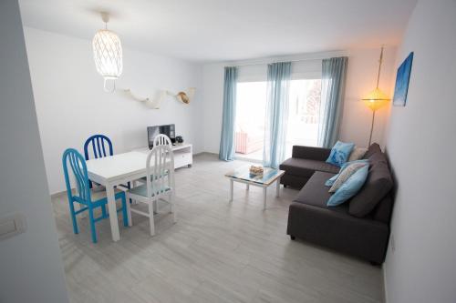 - un salon avec un canapé, une table et des chaises dans l'établissement Apartamento SARA en el complejo Teguisol, à Costa Teguise