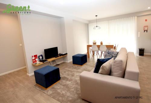 a living room with a couch and a tv at Apartamento Mãe de Deus in Ponta Delgada