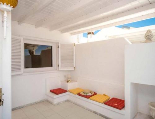 a bathroom with white walls and red and yellow cushions at Villa Arcelia in Puerto del Carmen