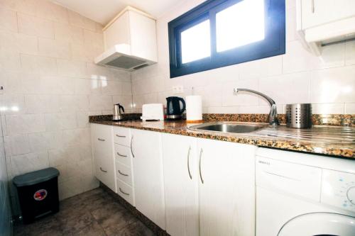 a small kitchen with a sink and a window at Dúplex Vista Mar Puerto Del Carmen in Puerto del Carmen