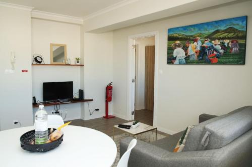 Apartamento Mãe de Deus في بونتا ديلغادا: غرفة معيشة مع أريكة وطاولة