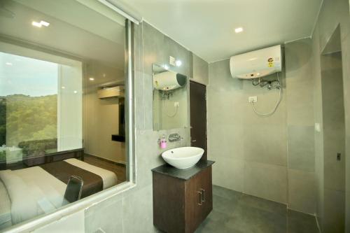 un baño con lavabo y espejo en Dasmaya resort, en Udaipur