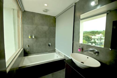 baño con lavabo, bañera y ventana en Dasmaya resort, en Udaipur