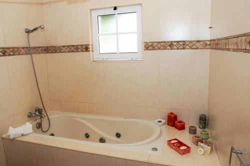 y baño con bañera y ventana. en Batalha House, en Ponta Delgada