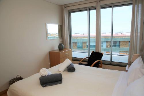 um quarto com uma cama e uma grande janela em Rooftop Terrace Apartment PDL em Ponta Delgada
