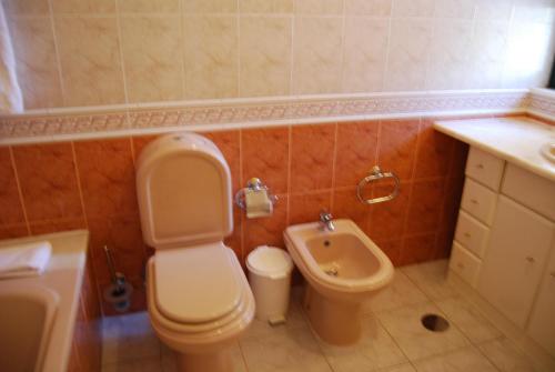 een badkamer met een toilet, een bidet en een wastafel bij Pestana Golf Resort - T2 71d in Carvoeiro