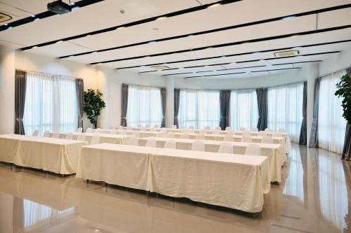 a banquet hall with white tables and white chairs at The Galla Hotel in Ranong