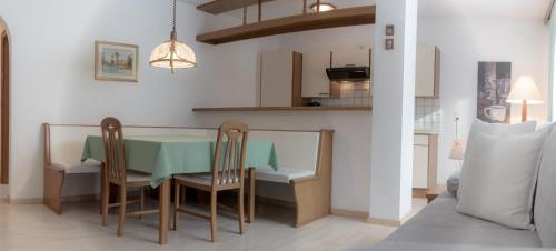a kitchen and dining room with a table and chairs at das Alpenblick & Outdoor Lodge Nauders in Nauders