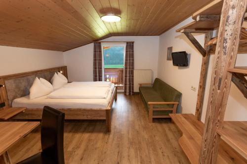 ein Schlafzimmer mit einem Bett, einem Stuhl und einem Fenster in der Unterkunft Hubergut Appartements in Radstadt