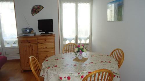 une table de salle à manger avec un vase de fleurs dessus dans l'établissement T2 Luchon Centre 5 nuits minimum, à Luchon