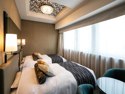 a hotel room with two beds and a window at APA Hotel Nihombashi Bakurocho Ekimae in Tokyo