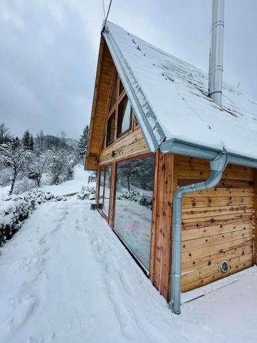 a log cabin with snow on the roof at Zaovinska idila in Bjeluša