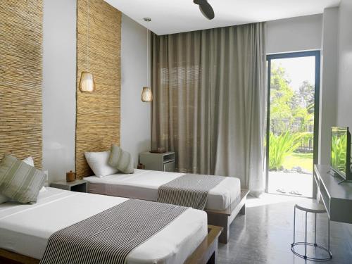 a hotel room with two beds and a television at Mahi Mahi Dive Resort in Zamboanguita