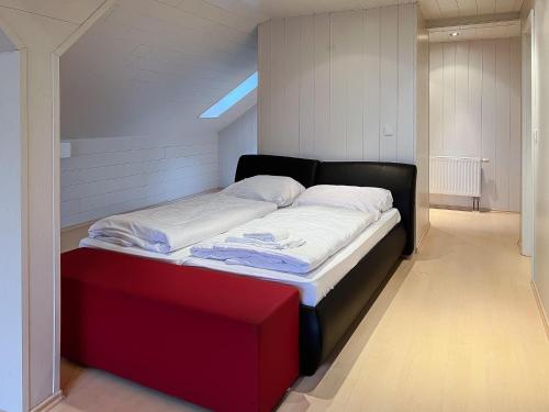 a large bed in a room with a red box at T&K Apartments - Erkrath - 4 Zimmer Apartments in Erkrath