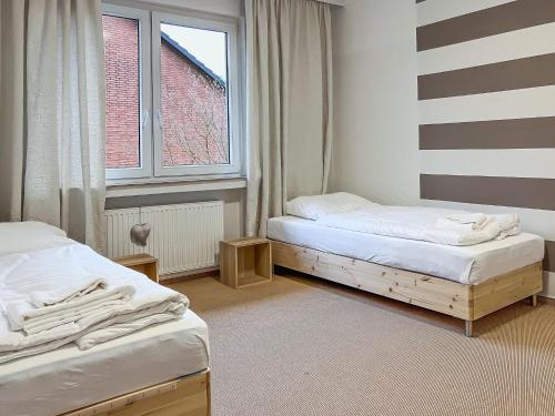 two twin beds in a room with a window at T&K Apartments - Erkrath - 4 Zimmer Apartments in Erkrath