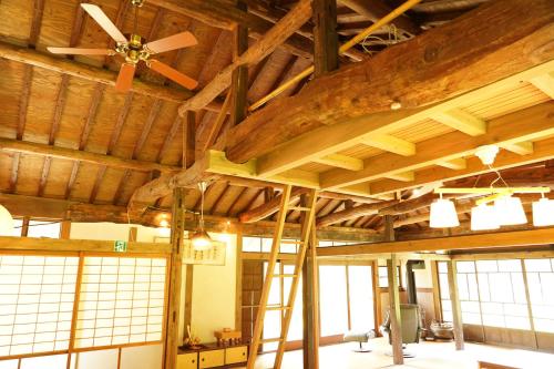 a room with wooden ceilings and a ceiling fan at しまなみ宿Gyoku in Imabari