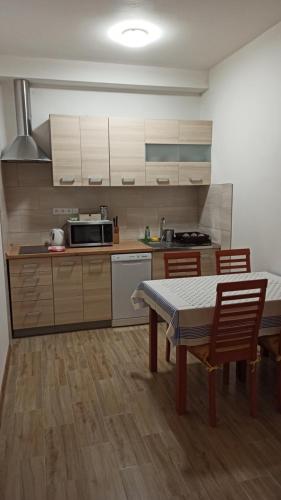 una cucina con tavolo e sedie e una cucina con armadietti bianchi di Apartmán Poděbrady a Poděbrady