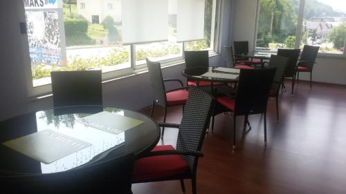a dining room with tables and chairs and windows at Motel Maks in Kiseljak