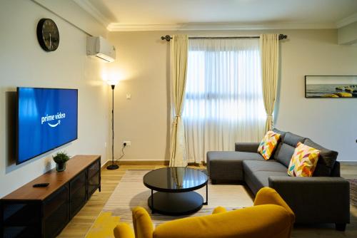 a living room with a couch and a tv at Westwood Residences in Arusha
