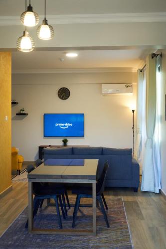 a living room with a blue couch and a table at Westwood Residences in Arusha