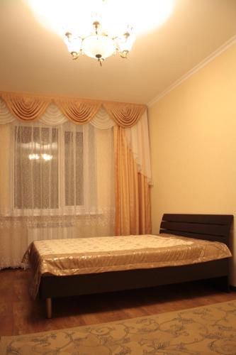 - une chambre avec un lit en face d'une fenêtre dans l'établissement Уральск, à Uralsk