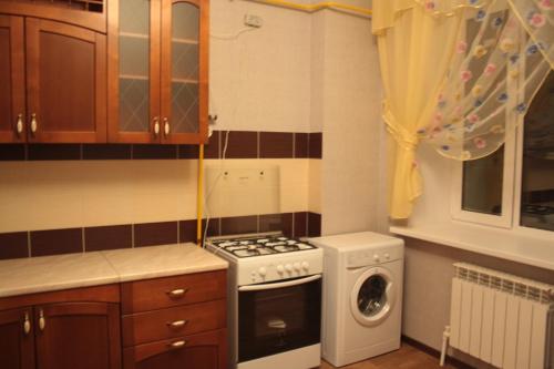 eine Küche mit einem Herd und einer Waschmaschine in der Unterkunft Уральск in Oral