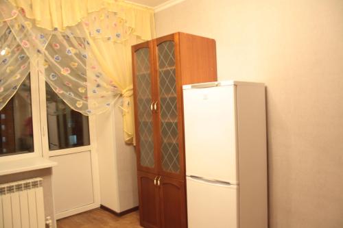 - un réfrigérateur dans une cuisine à côté d'une fenêtre dans l'établissement Уральск, à Uralsk