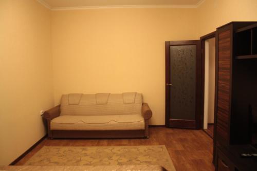 - un salon avec un canapé et une porte dans l'établissement Уральск, à Uralsk