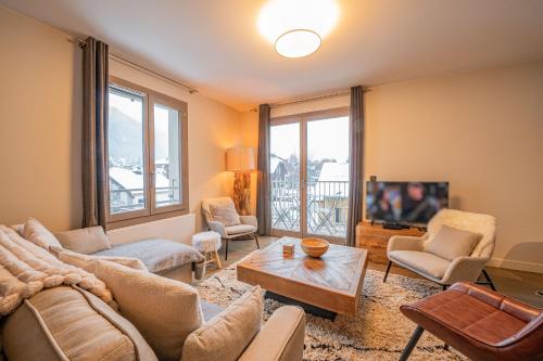 un salon avec un canapé et une télévision dans l'établissement Perle Blanche - Brand New 2 bedroom apartment perfectly located, à Chamonix-Mont-Blanc