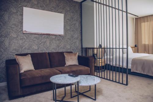 a living room with a couch and a bed at Hotel Sunce in Soko Banja