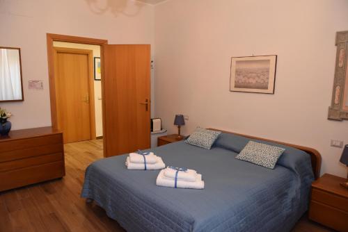 een slaapkamer met een blauw bed met handdoeken erop bij Camera e cameretta con bagno privato in Rome