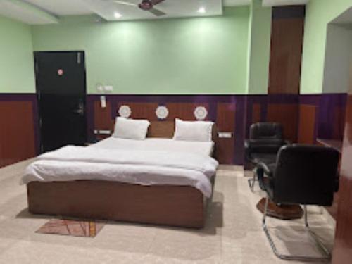 1 dormitorio con 1 cama grande y 2 sillas en Hotel 707 Bhubaneswar, en Bhubaneshwar