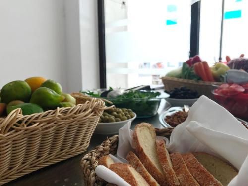 a table with baskets of bread and fruits and vegetables at Hotel Aleksandar in Budva