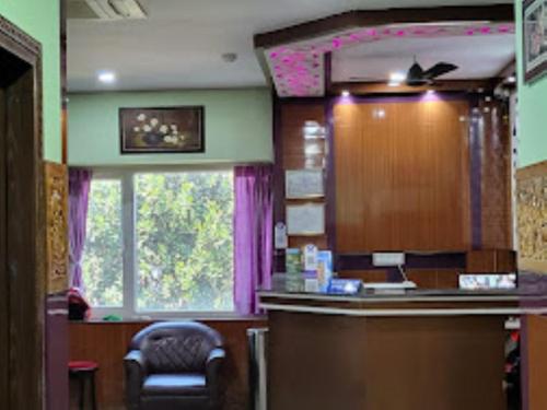 una sala de espera con una silla y una ventana en Hotel 707 Bhubaneswar, en Bhubaneshwar