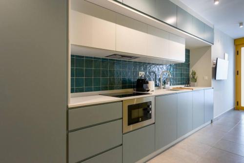 a kitchen with white cabinets and a stove at Estudio moderno y acogedor en Madrid Rio nº2 in Madrid