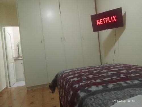 um quarto com uma cama e uma placa que lê netflix em Apartamento en Vilcabamba em Vilcabamba