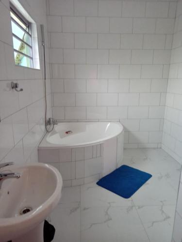 uma casa de banho branca com uma banheira e um lavatório em A Nice Homely 2- Bedroom House em Livingstone