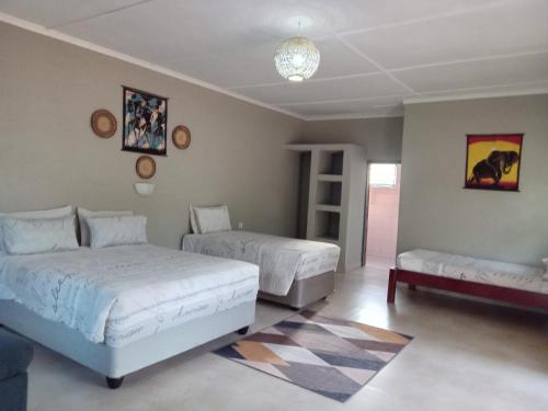 um quarto com 2 camas e um sofá em A Nice Homely 2- Bedroom House em Livingstone