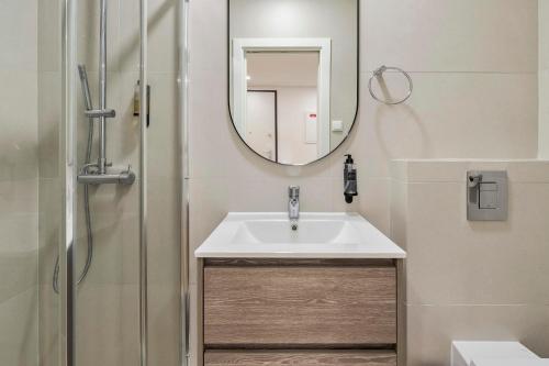 La salle de bains est pourvue d'un lavabo et d'un miroir. dans l'établissement Setubal Horizon Apartment, à Setúbal