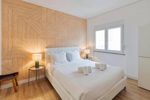 - une chambre avec un grand lit blanc et deux lampes dans l'établissement Setubal Horizon Apartment, à Setúbal